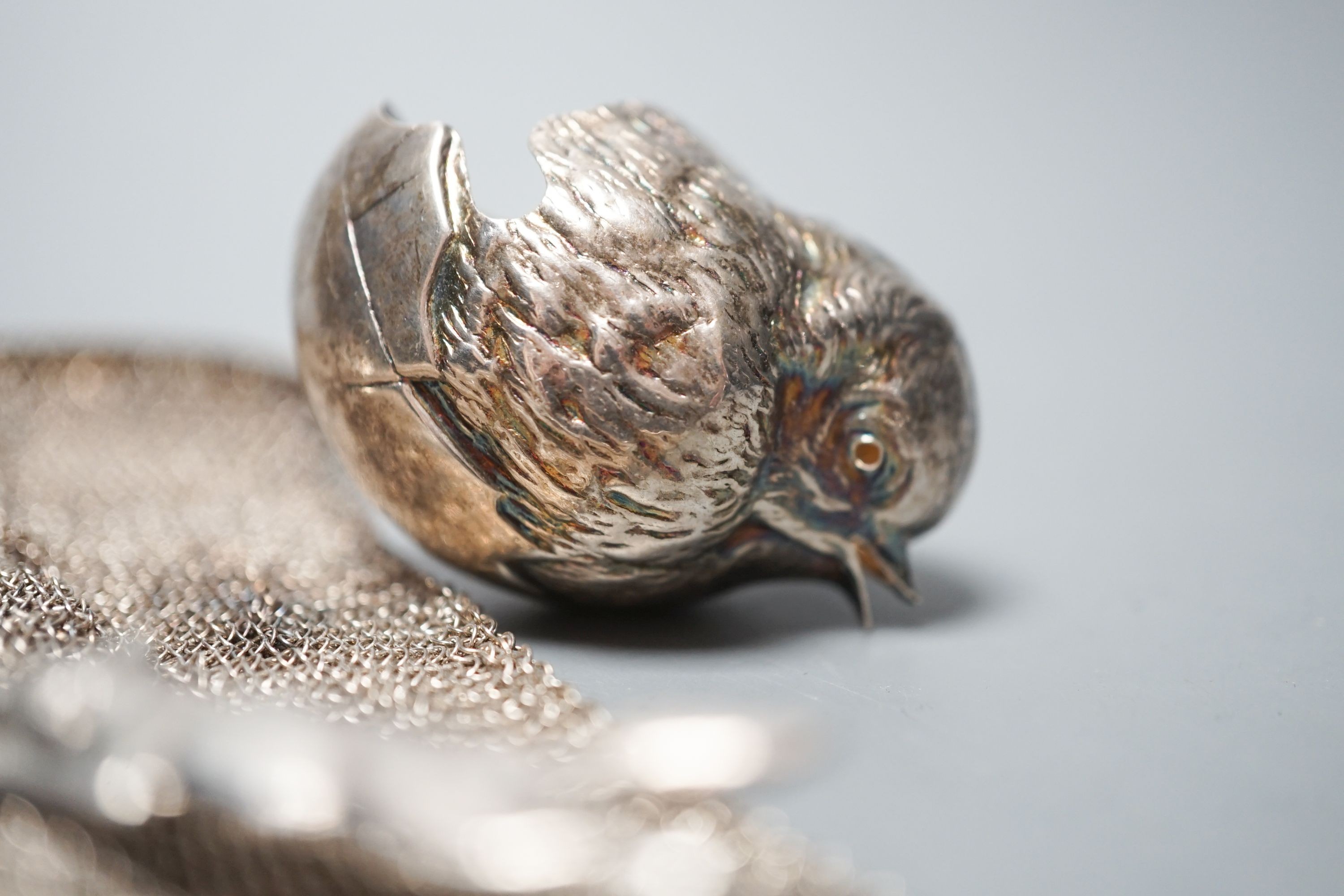 A George silver Arts & Crafts spoon, by Albert Edward Jones, two white metal mesh evening bags and a silver sparrow pourer spoon.